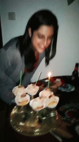 the woman is blowing out the candles on her cake