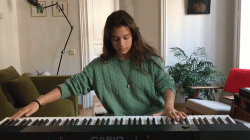 a woman playing music at the table with a piano