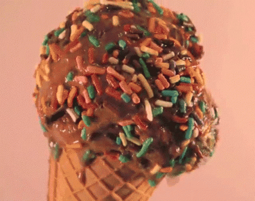 a big cone of ice cream with sprinkles on top
