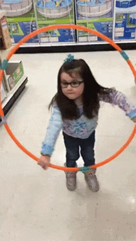 a child playing with a blue hoop in a grocery store