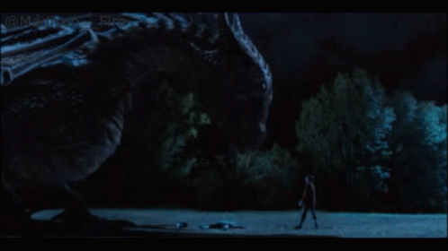 a man walking away from an enormous creature