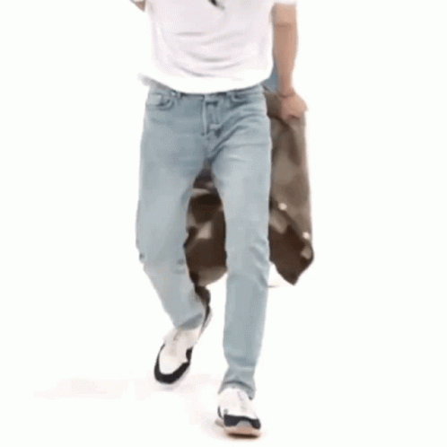 a man holding a bag and walking through a white room