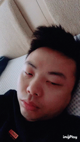a man that is laying down with his eyes closed