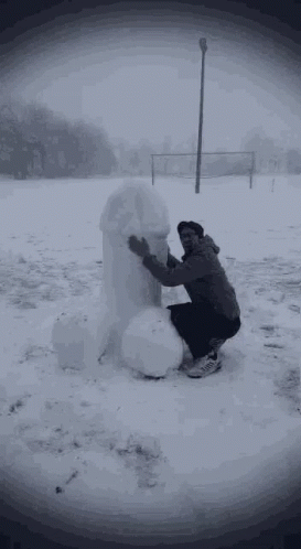 the man is making a snowman that has been made out of it