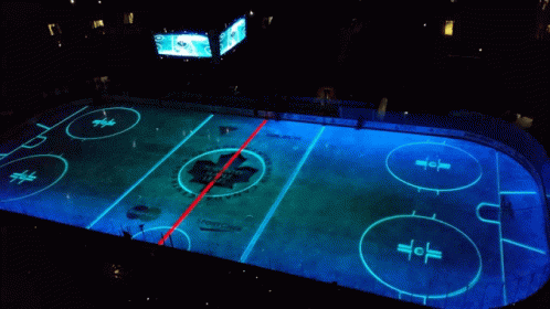an overhead view of the center court of a basketball court at night