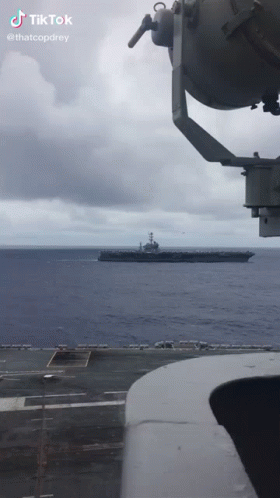 a large boat sailing across the ocean on top of an aircraft carrier