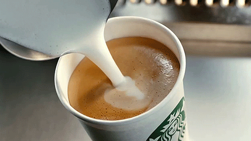 a cup of drink being poured into another one