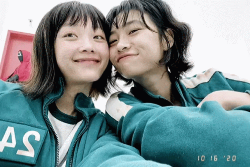 two women in a jacket taking a selfie