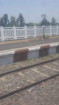 a small train speeding past an empty train station
