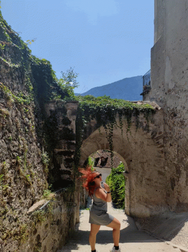 a woman walking on the walkway in a narrow alley