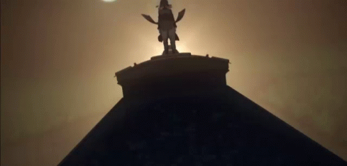 the silhouette of a statue atop a building at night