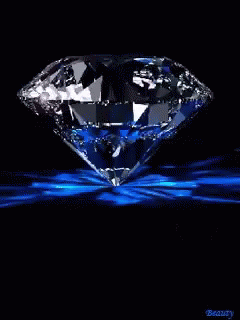 a diamond surrounded by light in a dark background