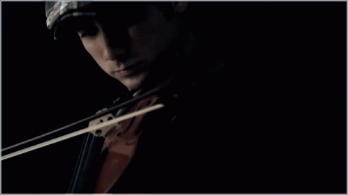 the dark picture is taken of a person with a violin