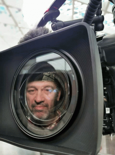 a camera being reflected in the reflection of another person