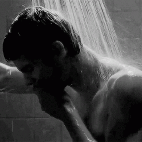 a man taking a shower from a small faucet