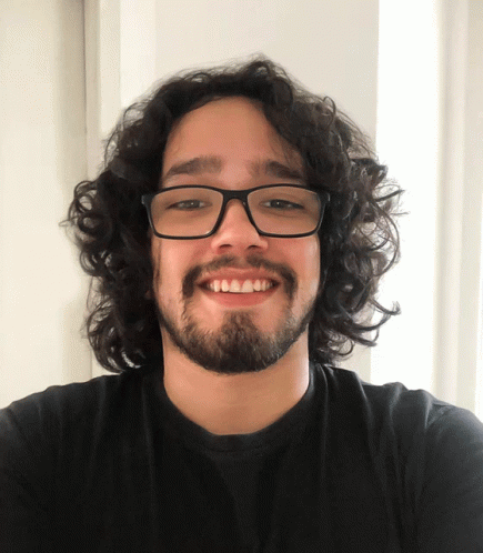 an image of a man with long hair and glasses smiling