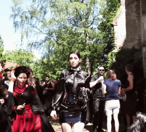 a woman dressed as an ancient character is walking with people around