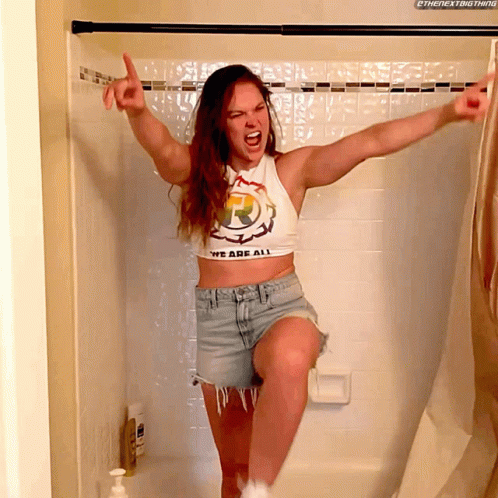 a girl is jumping in the air in a shower