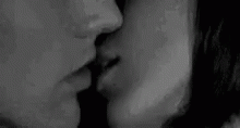 a black and white image of two people kissing