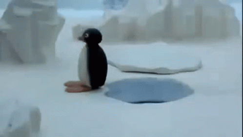 a small penguin sitting on top of a sandy beach