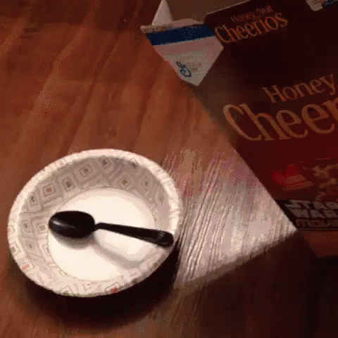 the bowl is next to a box of cereal