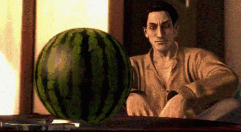 a picture of a man sitting behind a giant watermelon