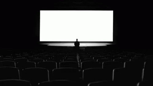 an empty room with chairs and a big screen in it