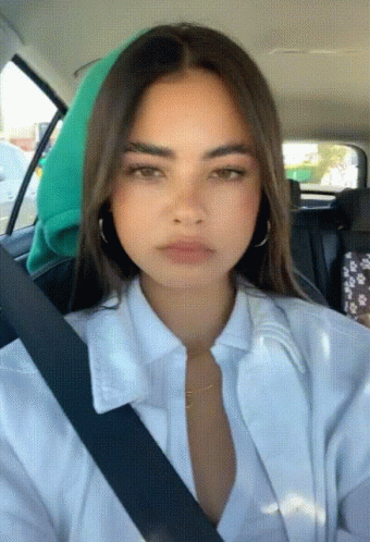 a girl in the back seat of a car wearing a dress and a tie