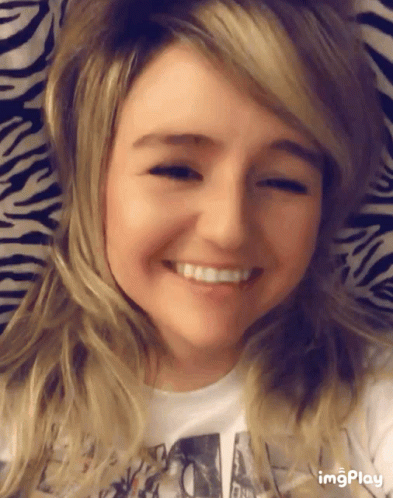 a girl smiling next to a ze print wallpaper