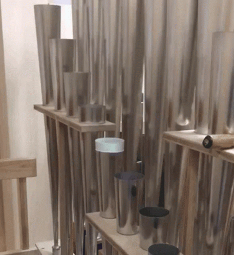 a wall of gray steel pipes inside a room