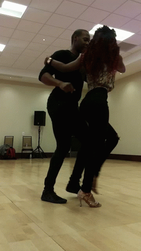 two young women are dancing in an empty room