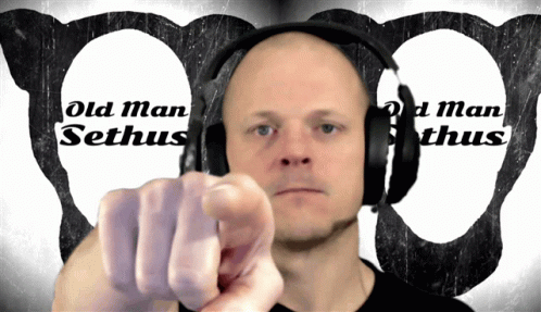 a man points to the side while wearing headphones