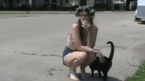a cat that is standing on a woman's stomach