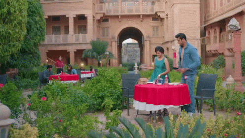 a couple is setting dinner in a very large garden