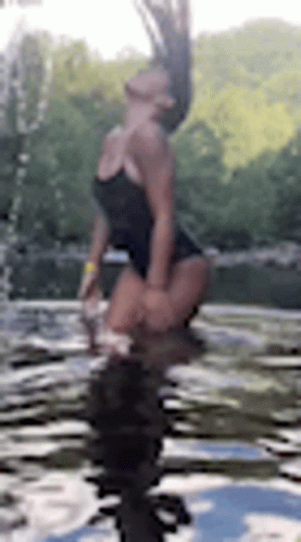 a woman doing a trick in the water on her feet
