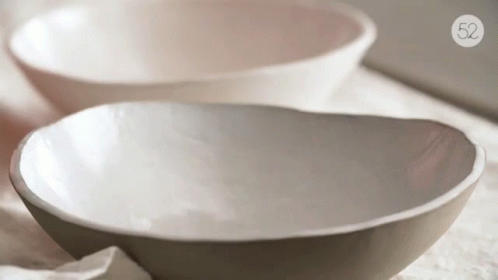 several white bowls of different sizes on top of paper