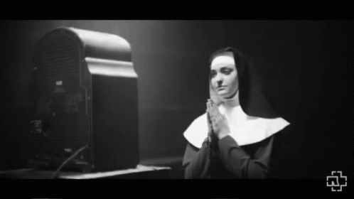 black and white po of man in nun costume looking at computer