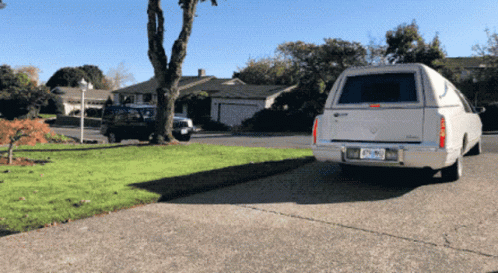 the back end of a van parked on the grass in front of a house