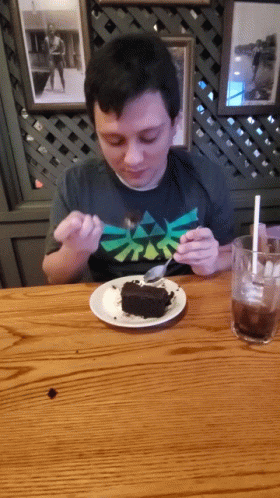 man eating cake with a plastic fork at a table