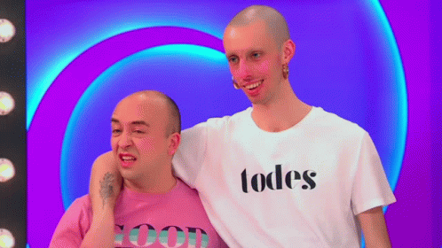 two men are smiling in front of a neon colored background