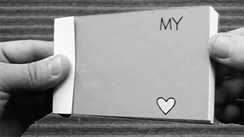 a person holds up a card that says, my heart is in the corner