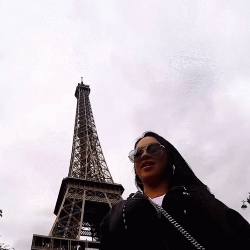 the lady is posing in front of the eiffel tower