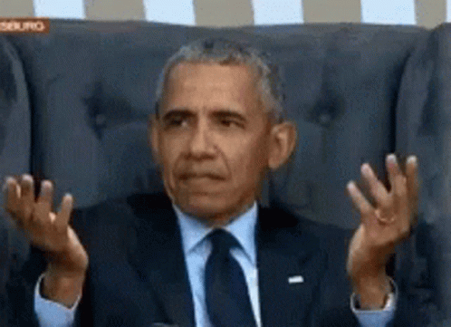obama is shown sitting in a chair with his hands up in a funny pose