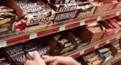 a hand is picking items off the shelves in a store