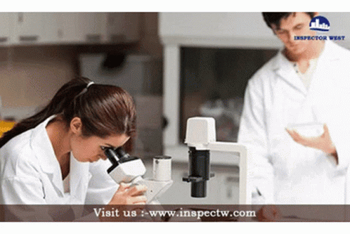 two people dressed as doctors look through microscopes
