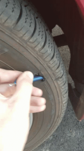 person in white gloves putting on an old lighter next to tire