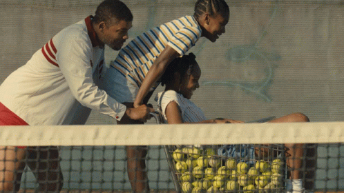 three people that are on a tennis court with a ball net