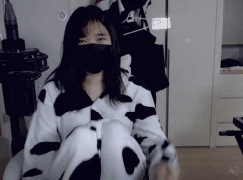 a woman in a cow costume sitting next to a person