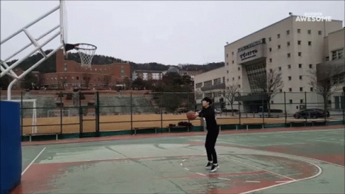 young man about to swing at basketball during tennis match