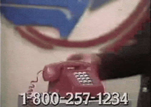 a cellphone on the wall near a purple telephone